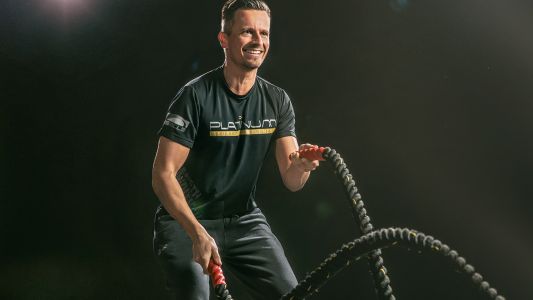 Dieses dynamische Fitnessfoto aufgenommen von dem Frankfurter Fotografen Fritz Philipp zeigt einen Sportler vor schwarzem Hintergrund der mit viel Spaß Seile schwingt