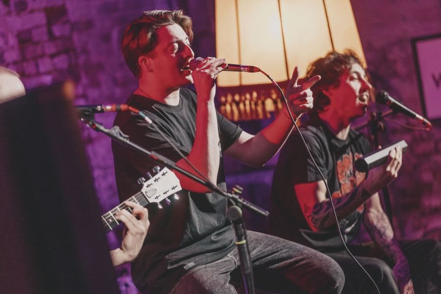 Die Band spielt, im Vordergrund die Silhouetten des Publikums – Sofakonzert von Die Dinners im Schärferaum