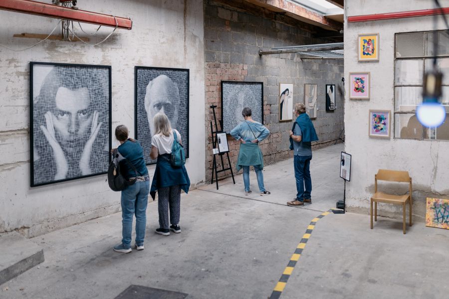 Besucherinnen vor großformatigen Schwarz-Weiß-Portraits an der Hallenwand – KunstWerkStadt im Schärferaum Bad Homburg