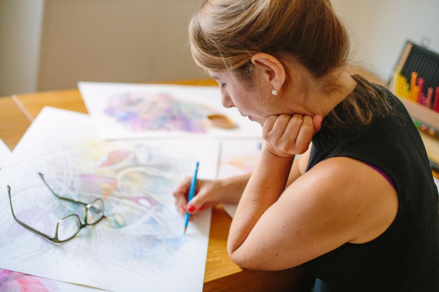 Portrait einer Künstlerin mit rotem Nagellack und blauem Stift beim Zeichnen. Fotografiert von dem Frankfurter Fotografen Fritz Philipp.