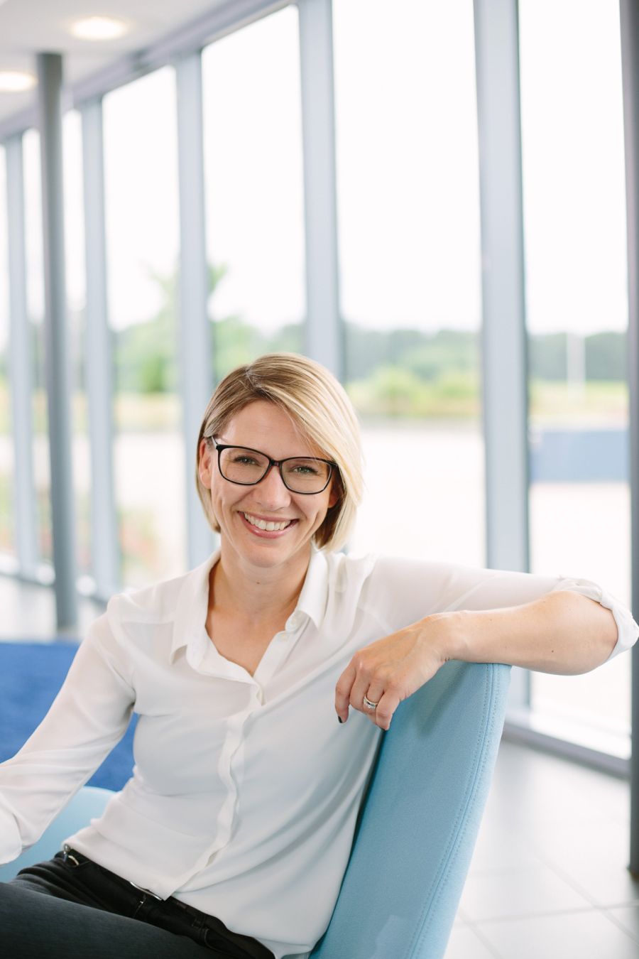 Businessportrait einer blonden Frau, passend zur Corporate Identity in Blautönen gehalten, von Fotograf Fritz Philipp aus Bad Homburg.