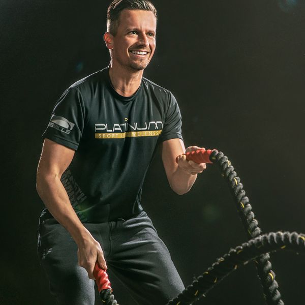 Dieses dynamische Fitnessfoto aufgenommen von dem Frankfurter Fotografen Fritz Philipp zeigt einen Sportler vor schwarzem Hintergrund der mit viel Spaß Seile schwingt