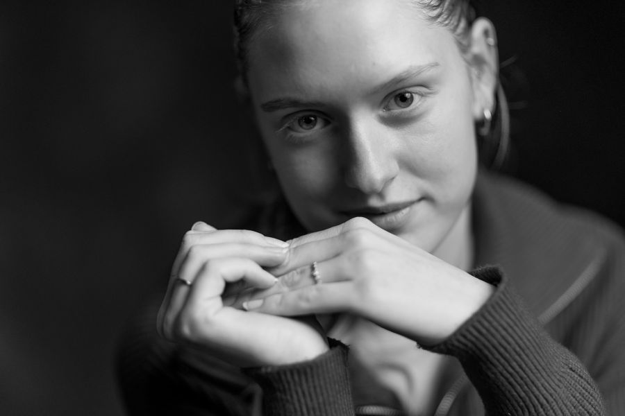 Schwarz-Weiß-Portrait einer jungen Frau, die die Hände vor dem Gesicht zusammenlegt und ruhig in die Kamera schaut – Schwarz-Weiß-Portrait bei der KunstWerkStadt im Schärferaum Bad Homburg
